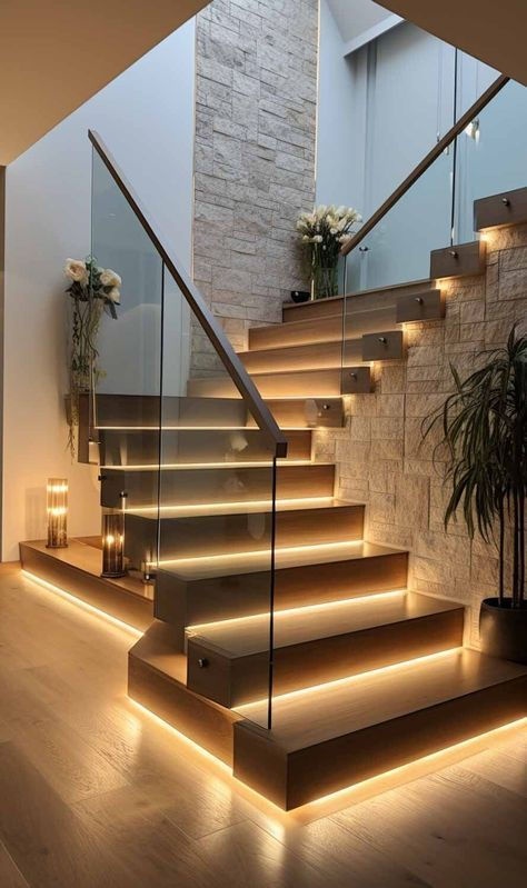 Modern luxury staircase interior in Indore featuring wooden steps, integrated LED strip lighting, and a glass railing.