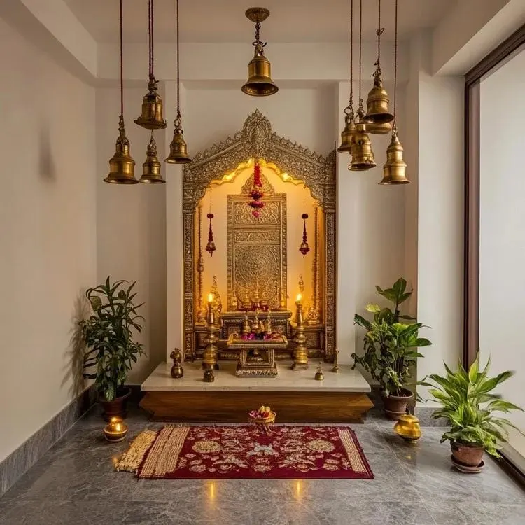 Traditional Indian home temple interior in Indore featuring an ornate brass mandir, hanging bells, and warm lighting.